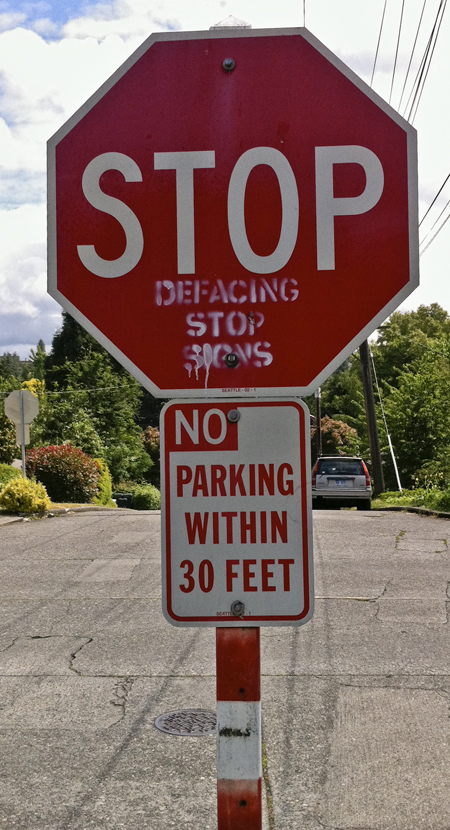 A stop sign defaced with the instruction Stop defacing stop signs